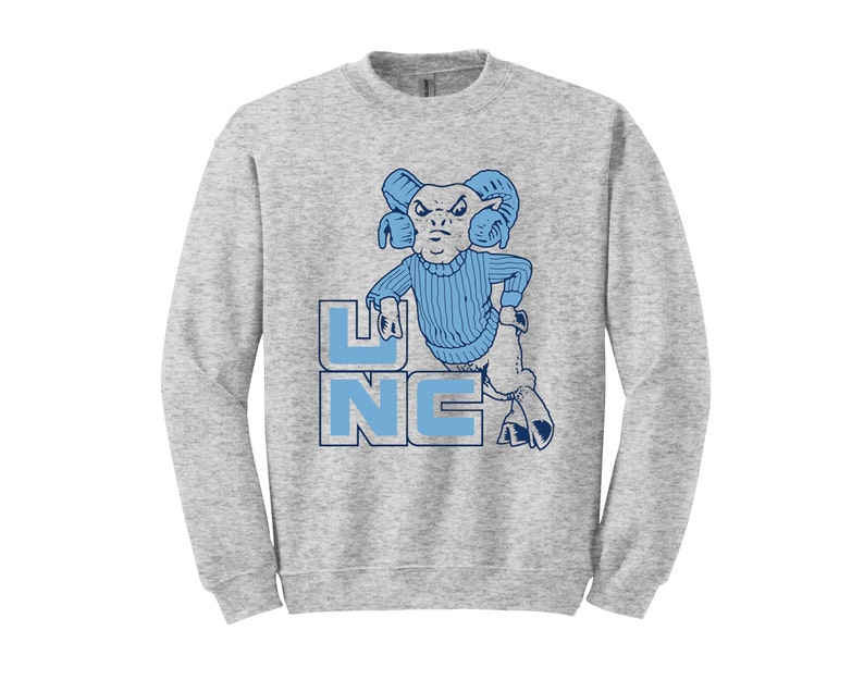 May include: A gray sweatshirt with a blue and white illustration of a ram wearing a blue sweater and the letters "UNC" in blue.