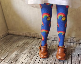 May include: Blue tights with a rainbow and smiley face pattern. The tights are worn with brown leather shoes with buckles.