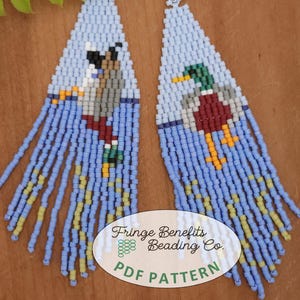 Peut inclure: Une paire de boucles d'oreilles en franges bleues et jaunes avec un motif de canard et d'oiseau. Les boucles d'oreilles sont faites à la main et présentent un design en franges. Les boucles d'oreilles sont étiquetées "Fringe Benefits Beading Co. PDF Pattern".