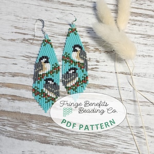 May include: A pair of long, teardrop-shaped beaded earrings featuring a light blue background with a pattern of black, white, and grey birds perched on green branches. The earrings have silver-toned metal hooks and a white oval label with the text Fringe Benefits Beading Co. PDF PATTERN.