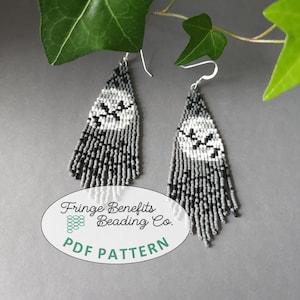 May include: A pair of beaded earrings with a geometric design. The earrings feature a black, white, and gray color scheme with a fringe bottom. The earrings are hanging from silver hooks. The text "Fringe Benefits Beading Co. PDF PATTERN" is on the bottom.