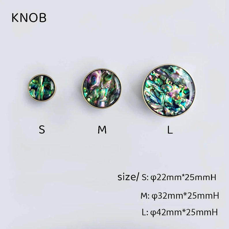 Op de afbeelding: Drie ronde kastknoppen met een gouden metalen basis en een iriserende parelmoer schelp inleg. De knoppen zijn verkrijgbaar in drie maten: klein, medium en groot. De tekst "KNOB" staat bovenaan de afbeelding. De tekst "size/ S: &phi;22mm*25mmH M: &phi;32mm*25mmH L: &phi;42mm*25mmH" staat onderaan de afbeelding.