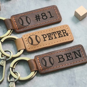 May include: Three brown leather keychains with gold metal key rings. Each keychain has a baseball graphic and personalized text: #81, PETER, and BEN.