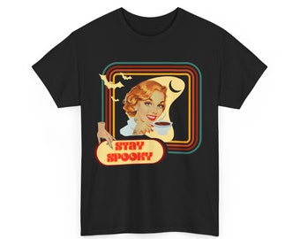 May include: Black t-shirt featuring a retro-style graphic of a woman drinking from a cup. The graphic has a multi-coloured border and the text "Stay Spooky" in red and white.