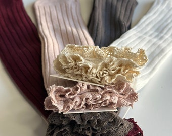 Peut inclure: Quatre paires de chaussettes hautes avec bordure en dentelle. Les chaussettes sont en bordeaux, beige, marron et blanc.