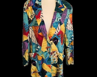 May include: A colorful blazer with a vibrant geometric pattern. The jacket features a mix of shapes and colors, including blue, yellow, red, and purple. It has a classic lapel and two front pockets, displayed on a mannequin.