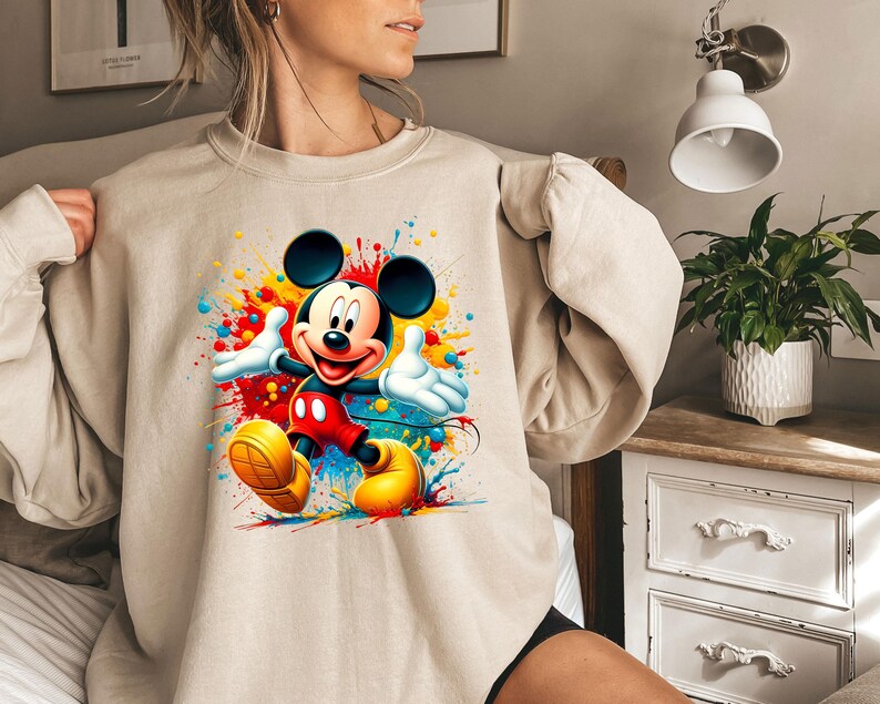a woman wearing a sweatshirt with a mickey mouse graphic on it