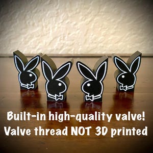 May include: Four black rabbit-shaped figures with white outlines and bow tie details. The text reads: Built-in high-quality valve! Valve thread NOT 3D printed. These objects feature a matte black finish and are arranged in a row on a dark surface.