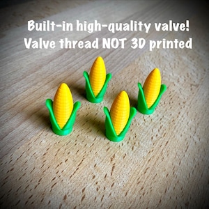 May include: Four small corn-shaped valve caps with yellow kernels and green husks. The text above reads: Built-in high-quality valve! Valve thread NOT 3D printed. These items feature a textured surface and a pointed top design.