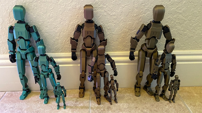 May include: Five articulated plastic figures in different sizes, ranging from small to large. The figures are all in shades of green and brown, with the largest figure being a dark green color. The figures are all standing upright and have a humanoid shape.
