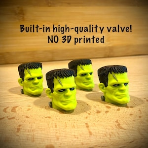 Könnte beinhalten: Vier grüne Frankenstein-Kopf-Figuren mit schwarzen Haaren und genähten Narben. Der Text "Built-in high-quality valve! NO 3D printed" steht über den Figuren. Die Figuren stehen auf einer Holzoberfläche.