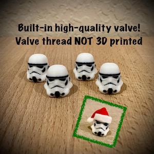 May include: Four white and black stormtrooper helmet valve caps with built-in high-quality valves and non-3D printed threads. An inset image shows one helmet wearing a red and white Santa hat. The text reads: Built-in high-quality valve! Valve thread NOT 3D printed.