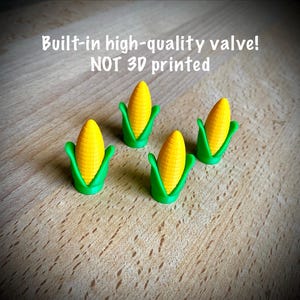 Op de afbeelding: Vier miniatuurbeeldjes van maïskolven. Elk heeft een geel maïskorrelontwerp met groene bladeren. De tekst in de afbeelding luidt: Built-in high-quality valve! NOT 3D printed.