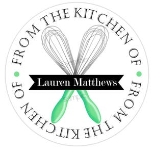 Pode incluir: Etiqueta redonda branca com texto preto que diz "From the Kitchen of" e "Lauren Matthews" com dois batedores verdes cruzados.