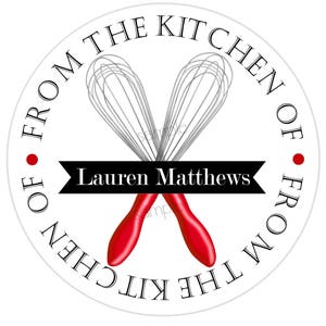 Pode incluir: Etiqueta redonda branca com texto preto que diz "From the Kitchen of" e "From the Kitchen of" em c&iacute;rculo. No centro, dois batedores vermelhos e prateados se cruzam. Uma faixa preta com texto branco diz "Lauren Matthews".
