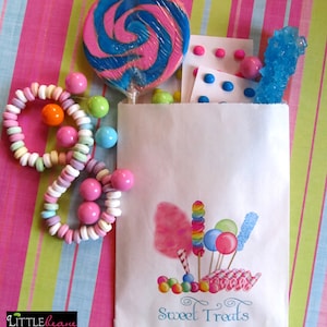 May include: A white paper bag with a candy theme. The bag has a colorful illustration of candy, cotton candy, and lollipops. The text "Sweet Treats" is printed on the bag. The bag is filled with candy, including a blue and pink swirl lollipop, a blue rock candy, and colorful candy bracelets.