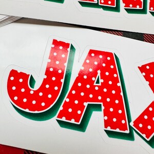 May include: Red and white polka dot letters spelling out the name "JAY" with a green outline. The letters are in a 3D style.