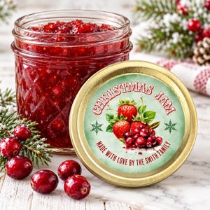May include: A glass jar filled with bright red jam, featuring a gold lid with a label that reads CHRISTMAS JAM and MADE WITH LOVE BY THE SMITH FAMILY, decorated with illustrations of strawberries, cranberries, and green snowflakes.