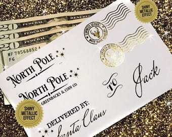 May include: A white sheet of stickers featuring black and gold metallic text and graphics. Designs include North Pole stamps, Express Service postmarks with a deer head, the text To Jack, and Delivered By: Santa Claus with star accents.