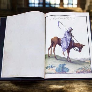 May include: An open book with a dark blue cover, displaying a detailed illustration of the Grim Reaper riding a brown horse. The Reaper is draped in a light purple cloak and holds a scythe. The page also includes handwritten text.