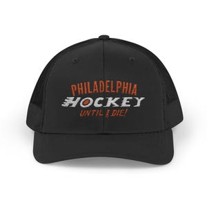 Può includere: Cappellino da camionista nero con la scritta ricamata "PHILADELPHIA HOCKEY UNTIL I DIE!" in arancione e bianco. Il cappellino ha un retro in rete e una visiera curva.