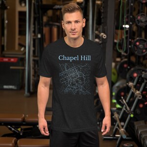 May include: A black t-shirt with a blue outline of a city map and the text "Chapel Hill" printed on the front.