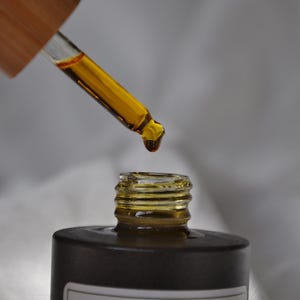 May include: A dark brown glass bottle with a dropper filled with a yellow liquid. The bottle is labelled "INLAB' SkinGlow Power C Oil Serum".