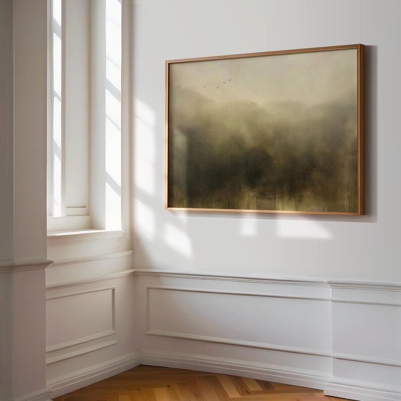 May include: A framed painting of a misty forest scene with a few birds flying in the distance. The painting is in a light wood frame and is hanging on a white wall.