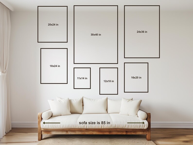 May include: A white sofa with a wooden frame and a measurement of 85 inches. The sofa is positioned in front of a white wall with several black picture frames of various sizes. The frames are labeled with measurements in inches.
