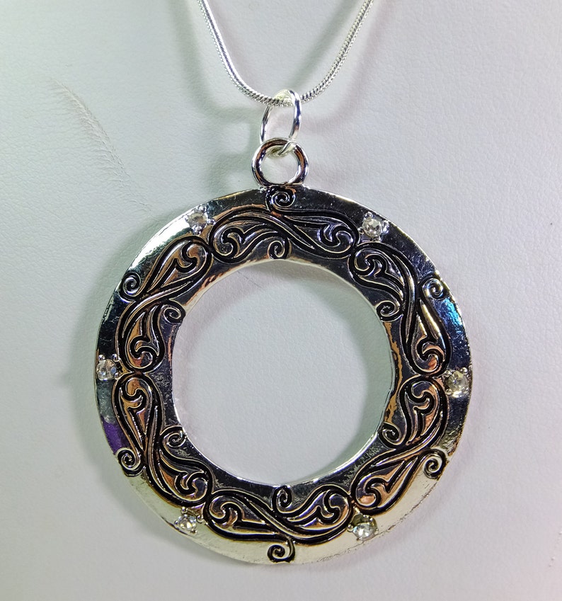 Large Metal Donut Pendant Enscribed with a Flowing Design and Tiny Crystal Embellishments on a Chain image 1