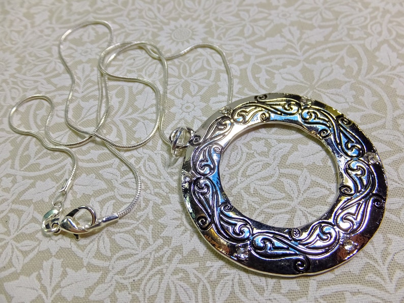 Large Metal Donut Pendant Enscribed with a Flowing Design and Tiny Crystal Embellishments on a Chain image 4