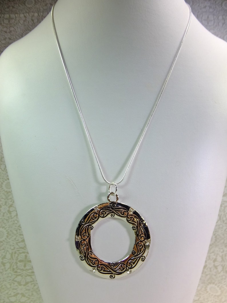 Large Metal Donut Pendant Enscribed with a Flowing Design and Tiny Crystal Embellishments on a Chain image 2