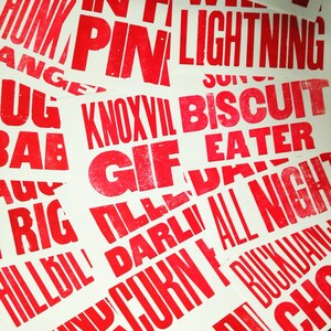 May include: Red text printed on white paper. The text includes words like "HUNK", "PIN", "LIGHTNING", "KNOXVIL", "BISCUIT", "GIF", "EATER", "TILLE", "DARLI", "ALL NIGHT", "CURN", "BUCKIJANG", and "CHS".