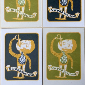 May include: Four vintage-style cards with a yellow and green illustration of a person with swords sticking out of their body. The text on the cards reads "Sword-Swallower".