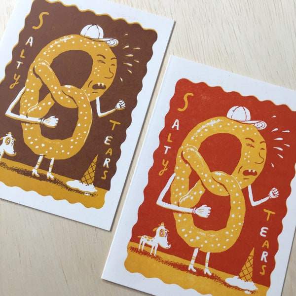 PAIR of SALTY TEARS Carnival greeting cards hand printed letterpress pretzel crying spilled milk sideshow art orange and brown card art