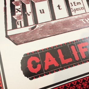 May include: A red and black vintage poster with the word "CALIF" in large red letters on a black background. The poster has a black and white illustration of a building with the words "3 Em Spaces" at the top.