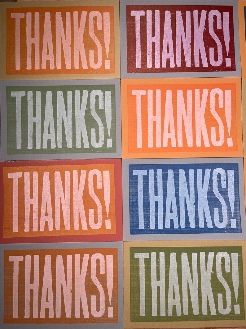 Puede incluir: Seis tarjetas con la palabra "THANKS!" impresa en blanco sobre fondos de diferentes colores. Los fondos son naranja, rojo, verde, azul, naranja y verde.