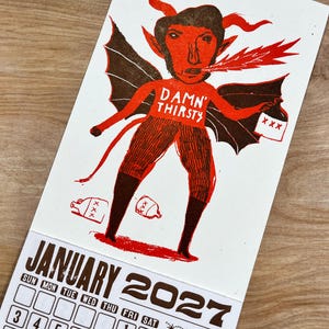 May include: A January 2027 calendar page featuring a red and brown illustration of a horned devil character with wings, breathing fire, and holding a jug labeled XXX. The text DAMN THIRSTY is printed on the chest, with additional jugs on the ground.
