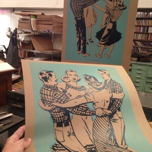 K&ouml;nnte beinhalten: Zwei Drucke im Vintage-Stil mit Paaren, die im Kreis tanzen. Die Illustrationen sind in Schwarz und Beige gehalten, mit einem hellblauen Hintergrund. Die Drucke sind auf beigem Karton, und einer wird von einer Person gehalten.
