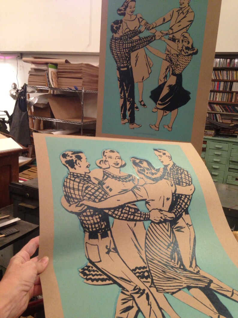 K&ouml;nnte beinhalten: Zwei Drucke im Vintage-Stil mit Paaren, die im Kreis tanzen. Die Illustrationen sind in Schwarz und Beige gehalten, mit einem hellblauen Hintergrund. Die Drucke sind auf beigem Karton, und einer wird von einer Person gehalten.