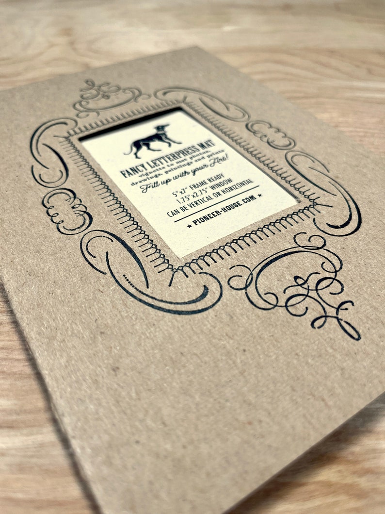 Peut inclure: Un tapis en papier brun avec un cadre noir d&eacute;coratif et une d&eacute;coupe pour une photo de 12,7x17,8 cm. Le tapis est &eacute;tiquet&eacute; "Fancy Letterpress Mat" et comprend des instructions pour "Fill up with your art!"  Le tapis est &eacute;galement &eacute;tiquet&eacute; "5"x7" Frame Ready 1.75"x2.75" Window Can be Vertical or Horizontal *Pioneer-House.com*"