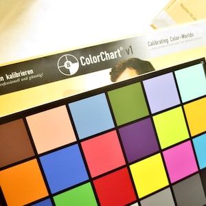 May include: ColorChart v1 color calibration chart with a grid of colorful squares. The chart includes a variety of colors, including brown, orange, blue, green, purple, pink, and yellow. The text "Farbwelten kalibrieren" is visible.