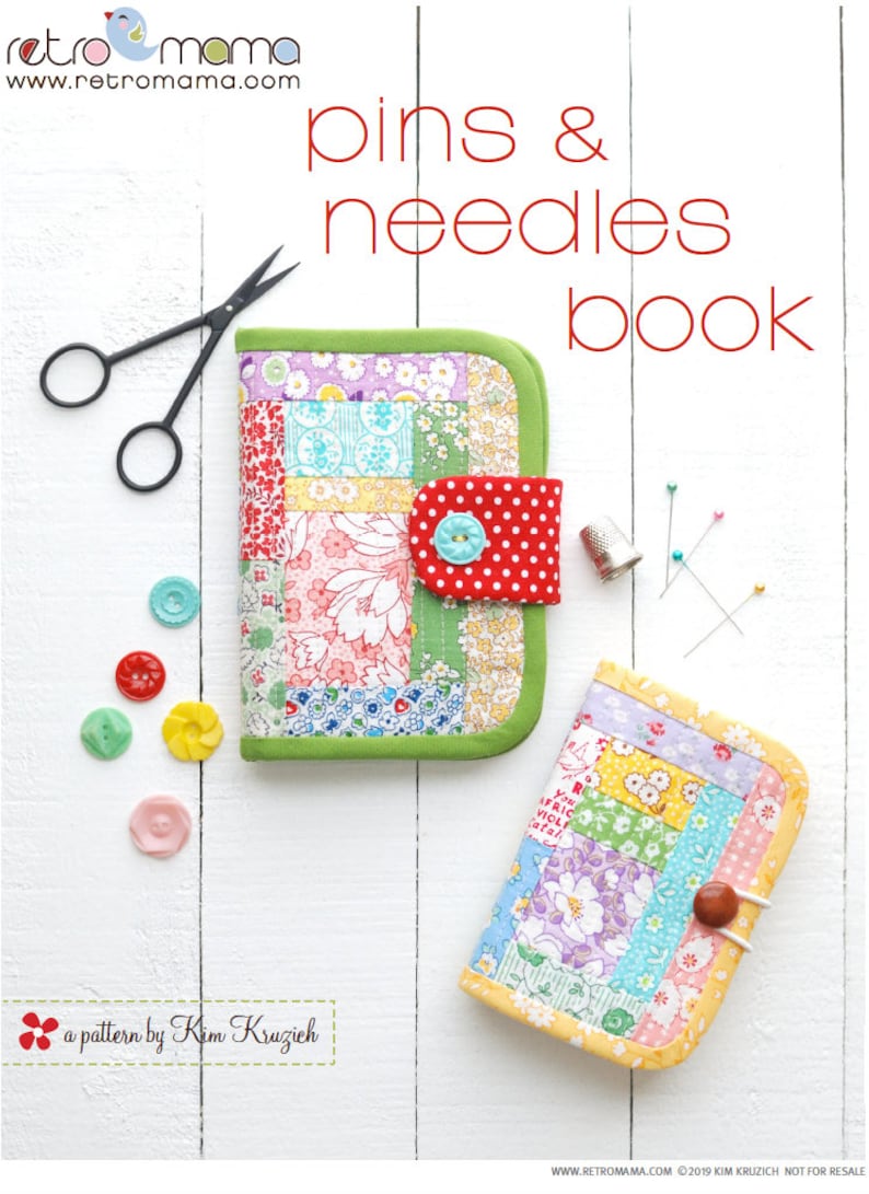 May include: A sewing project pattern for a pins and needles book. The book is made of patchwork fabric with a variety of floral and geometric patterns in shades of pink, blue, yellow, green, and red. The book has a green border and a red flap with white polka dots. The book is closed and sitting on a white wooden surface.