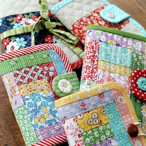 May include: A collection of colourful patchwork fabric pouches with different patterns and designs. The pouches have a variety of buttons and are perfect for storing small items.