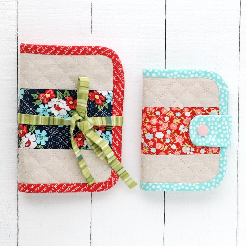 May include: Two quilted fabric zippered pouches with a floral print and a light blue trim. The larger pouch has a green ribbon tied around it. The smaller pouch has a pink button.