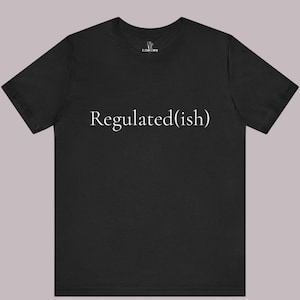 May include: A black short-sleeved t-shirt featuring the white text Regulated(ish) printed across the centre of the chest. The shirt has a crew neckline and a small white logo label on the inside of the neck area that reads The Laboratory.
