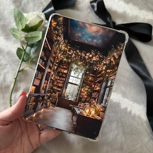 Peut inclure: Une coque de téléphone transparente avec une image de l'intérieur d'une bibliothèque. La bibliothèque a des étagères remplies de livres, une grande fenêtre et une guirlande florale suspendue au plafond. Le plafond est peint avec un ciel étoilé.