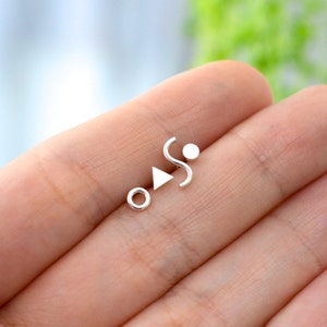 Mismatched geometric set of Memphis inspired triangle, squiggle, dot and donut sterling silver stud earrings for minimalist men or women