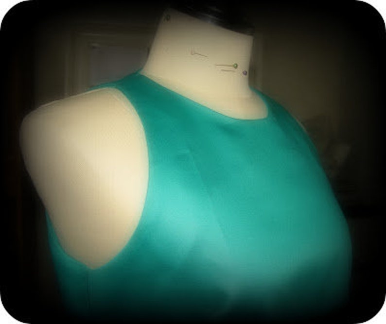 May include: A sleeveless, teal blue dress with a scoop neck.