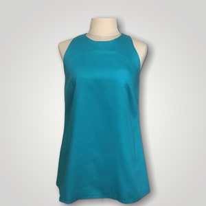 May include: A sleeveless, turquoise top with a round neckline. The top is made of a smooth, silky fabric.